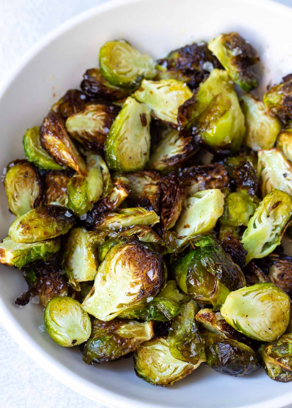 crisp browned air fryer brussels sprouts served in a white dish