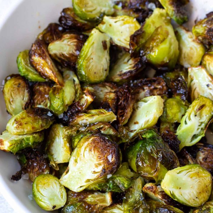 crisp browned air fryer brussels sprouts served in a white dish