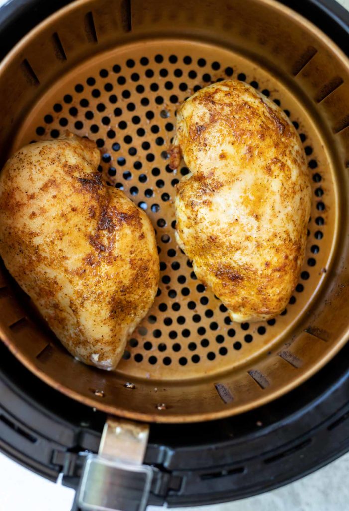 seasoned air fryer chicken breast in fryer basket