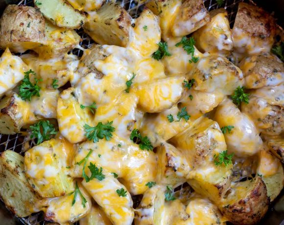 potatoes topped with melty cheese in air fryer basket
