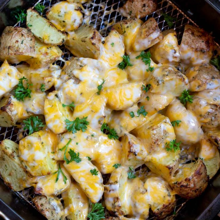 potatoes topped with melty cheese in air fryer basket