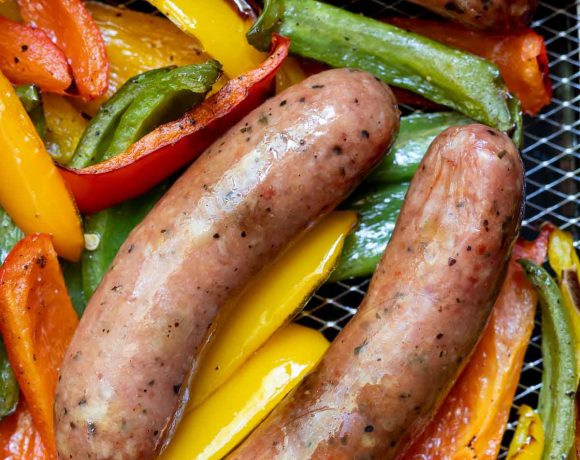 sausages and sliced peppers in air fryer basket