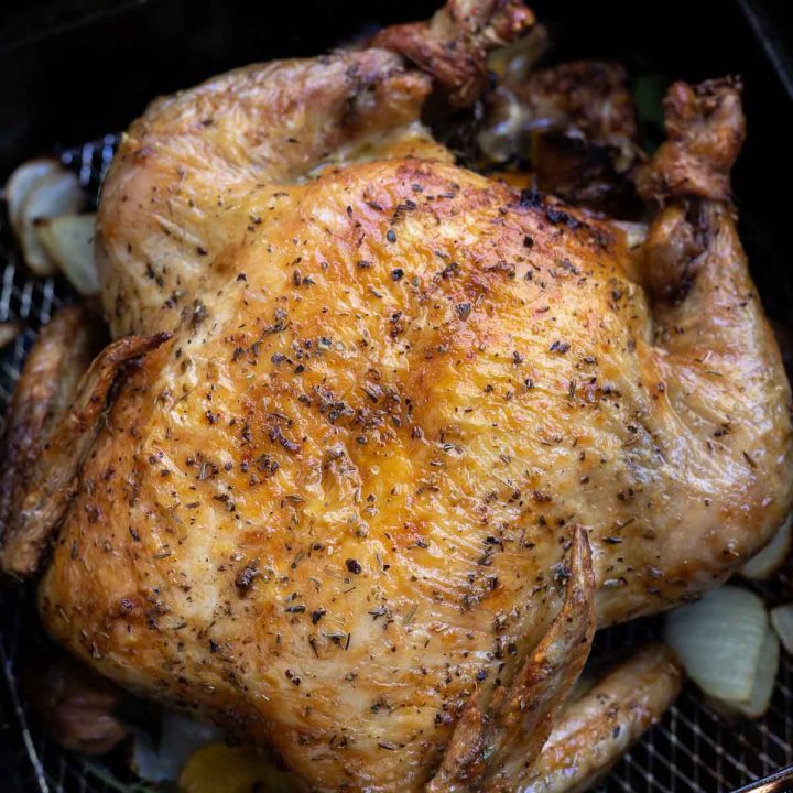 roasted chicken with golden brown skin in air fryer basket