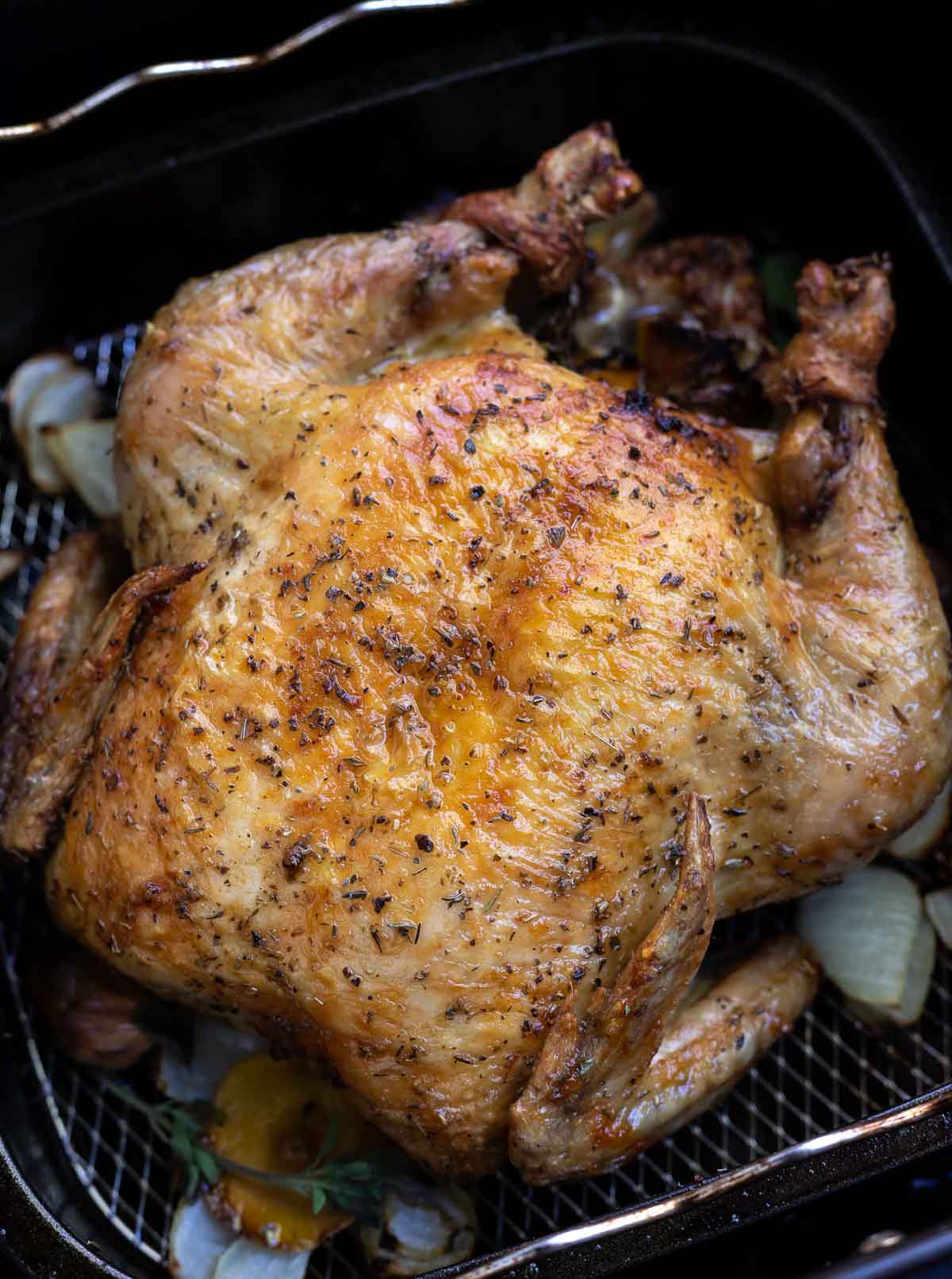 roasted chicken with golden brown skin in air fryer basket