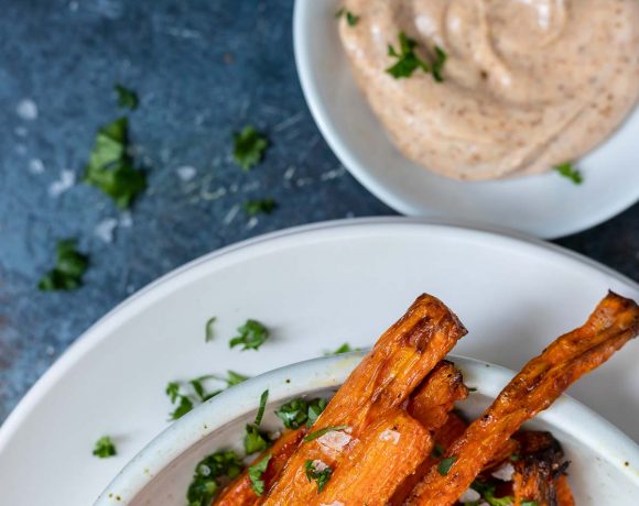 carrot fries on white plate next to creamy dip