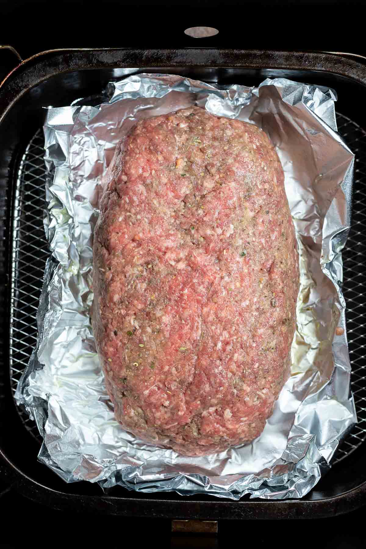 uncooked meatloaf in air fryer basket