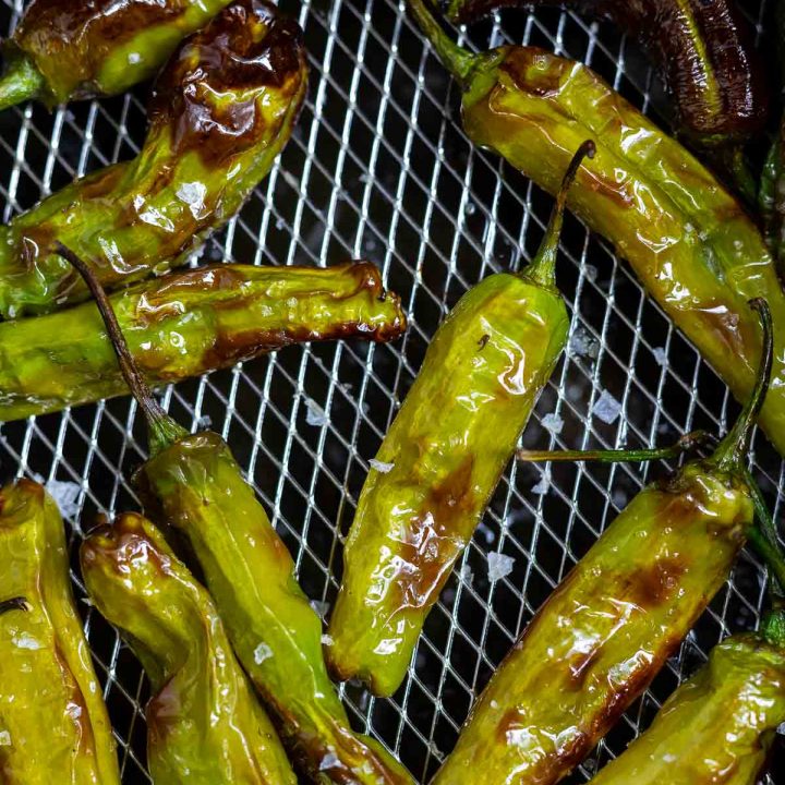 cooked shishito peppers in air fryer basket