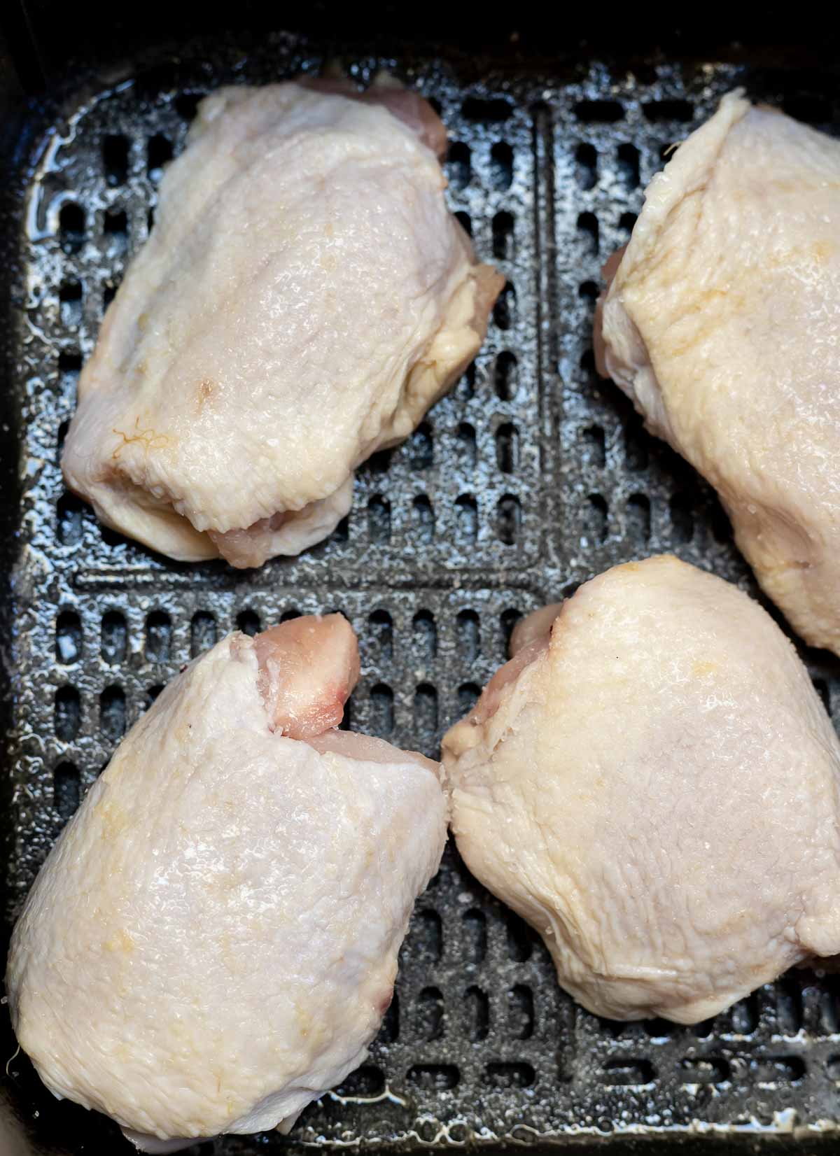 raw chicken thighs in air fryer basket