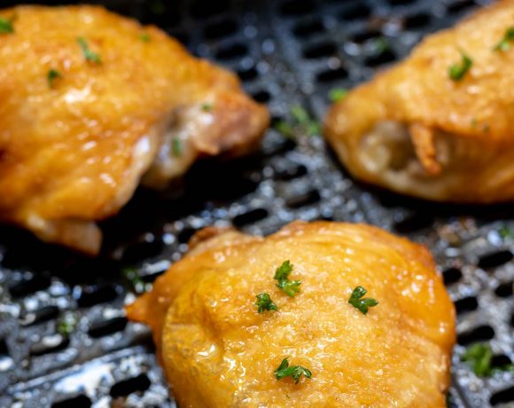 cooked golden skin chicken thighs in air fryer basket