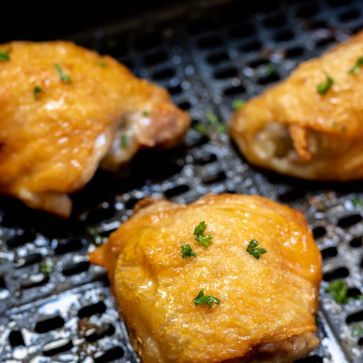 cooked golden skin chicken thighs in air fryer basket