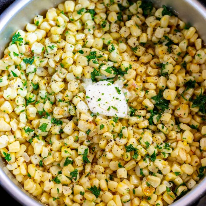 cooked corn with butter and parsley in metal pan