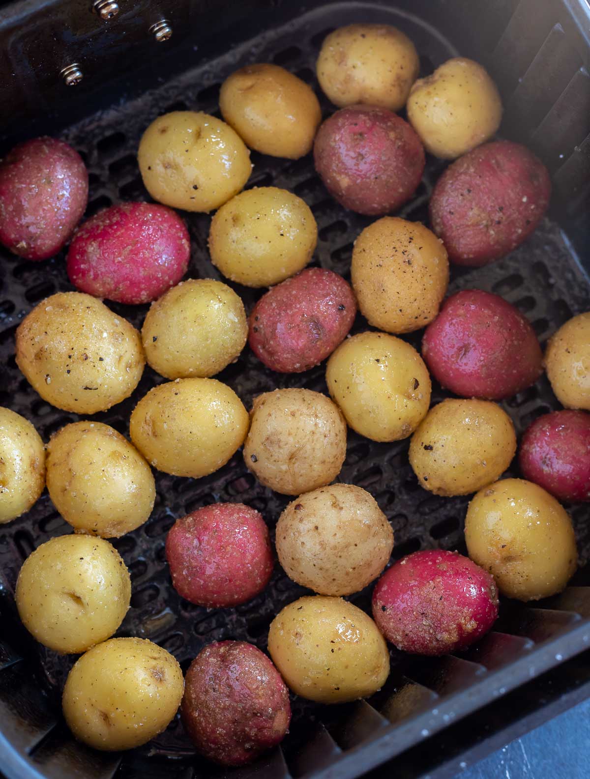 uncooked potatoes in air fryer basket