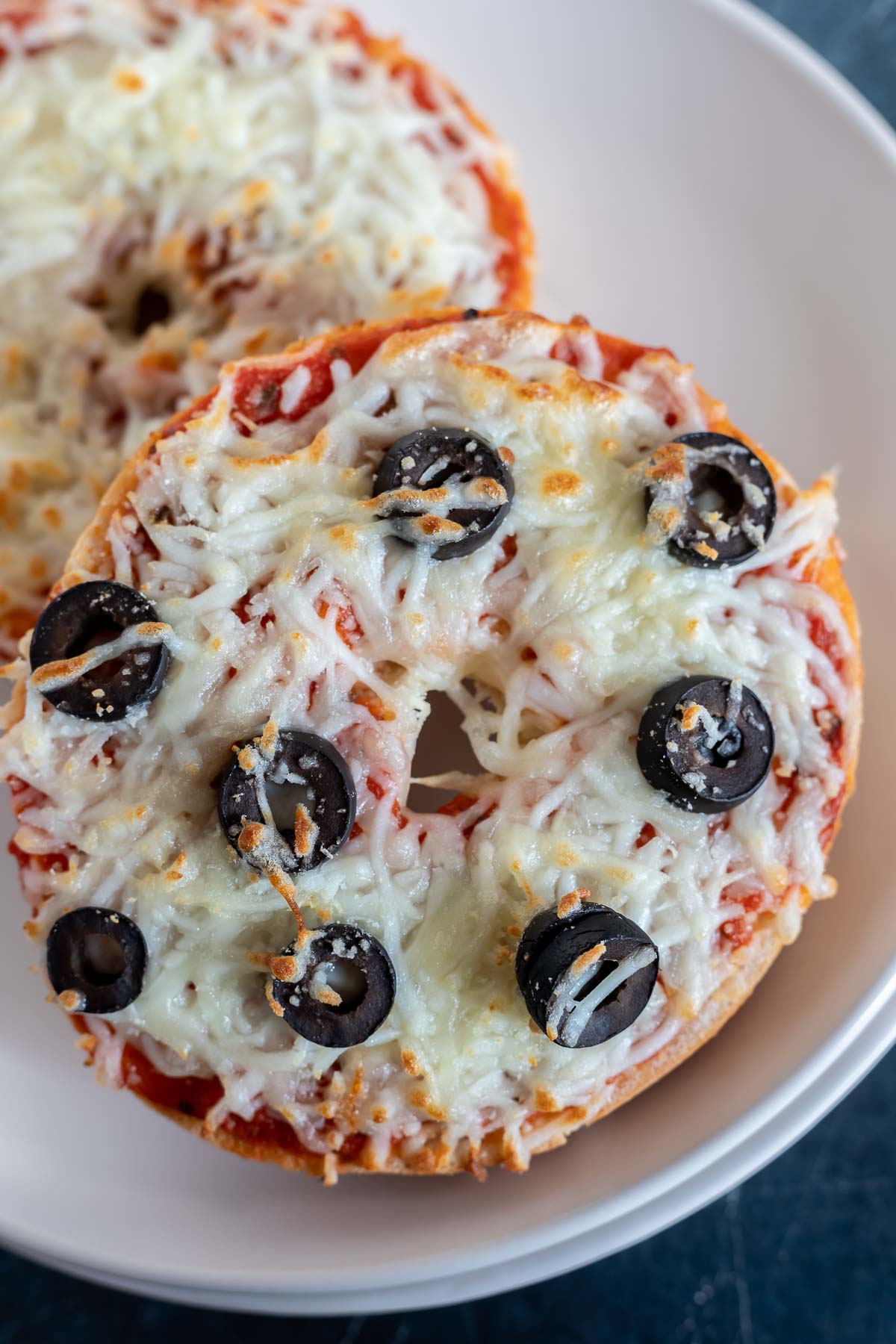 cooked pizza bagels on white plate