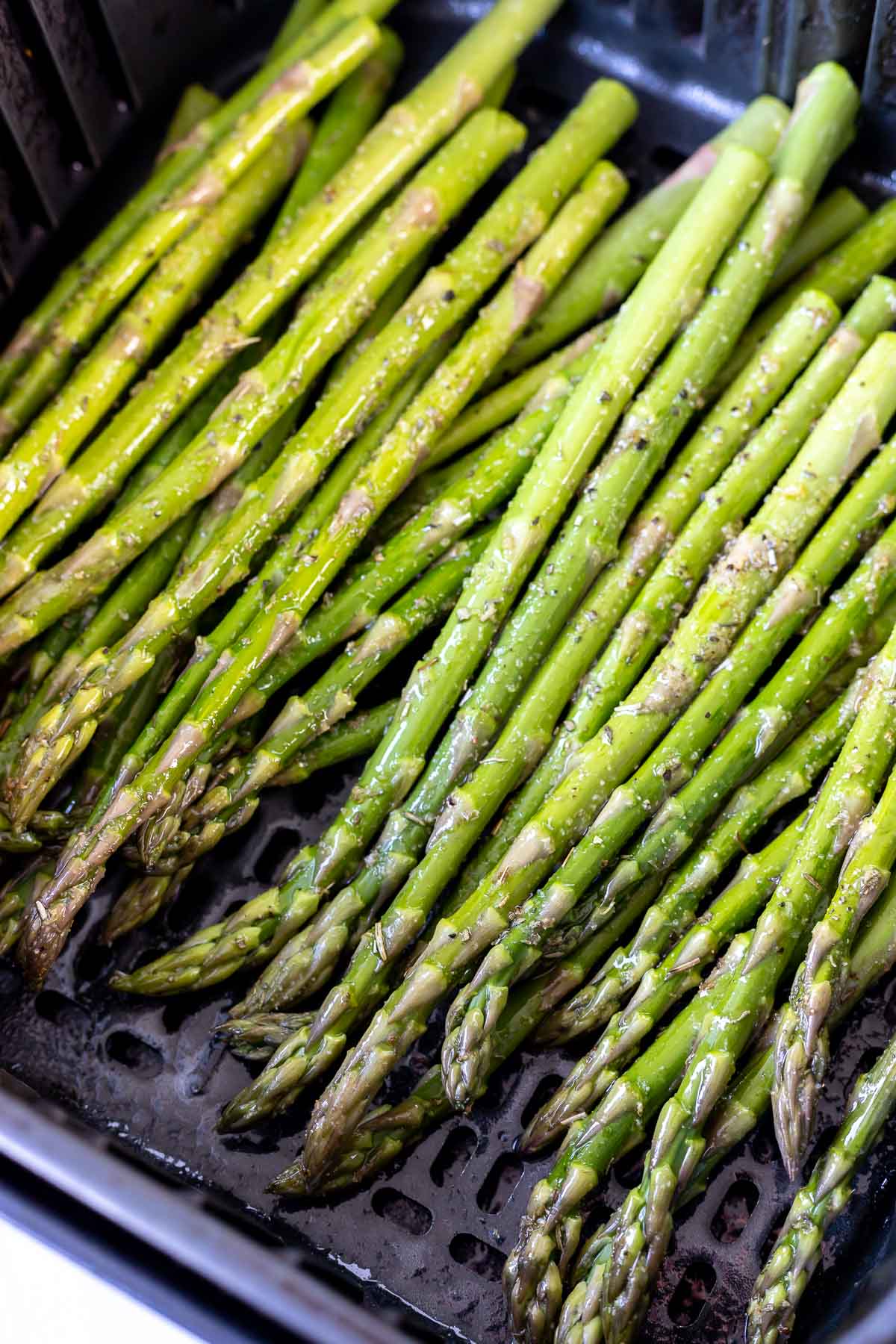 raw asparagus in air fryer basket
