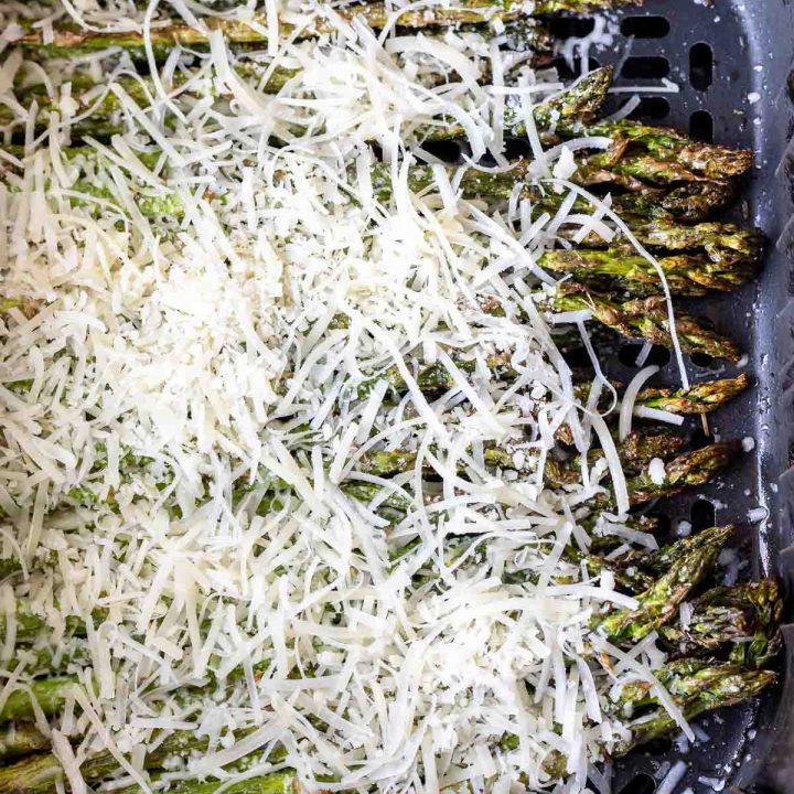 asparagus topped with parmesan in air fryer basket