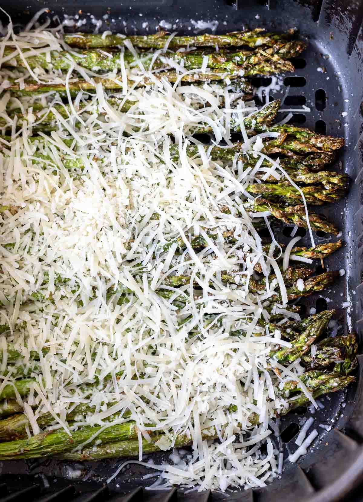 asparagus topped with parmesan in air fryer basket