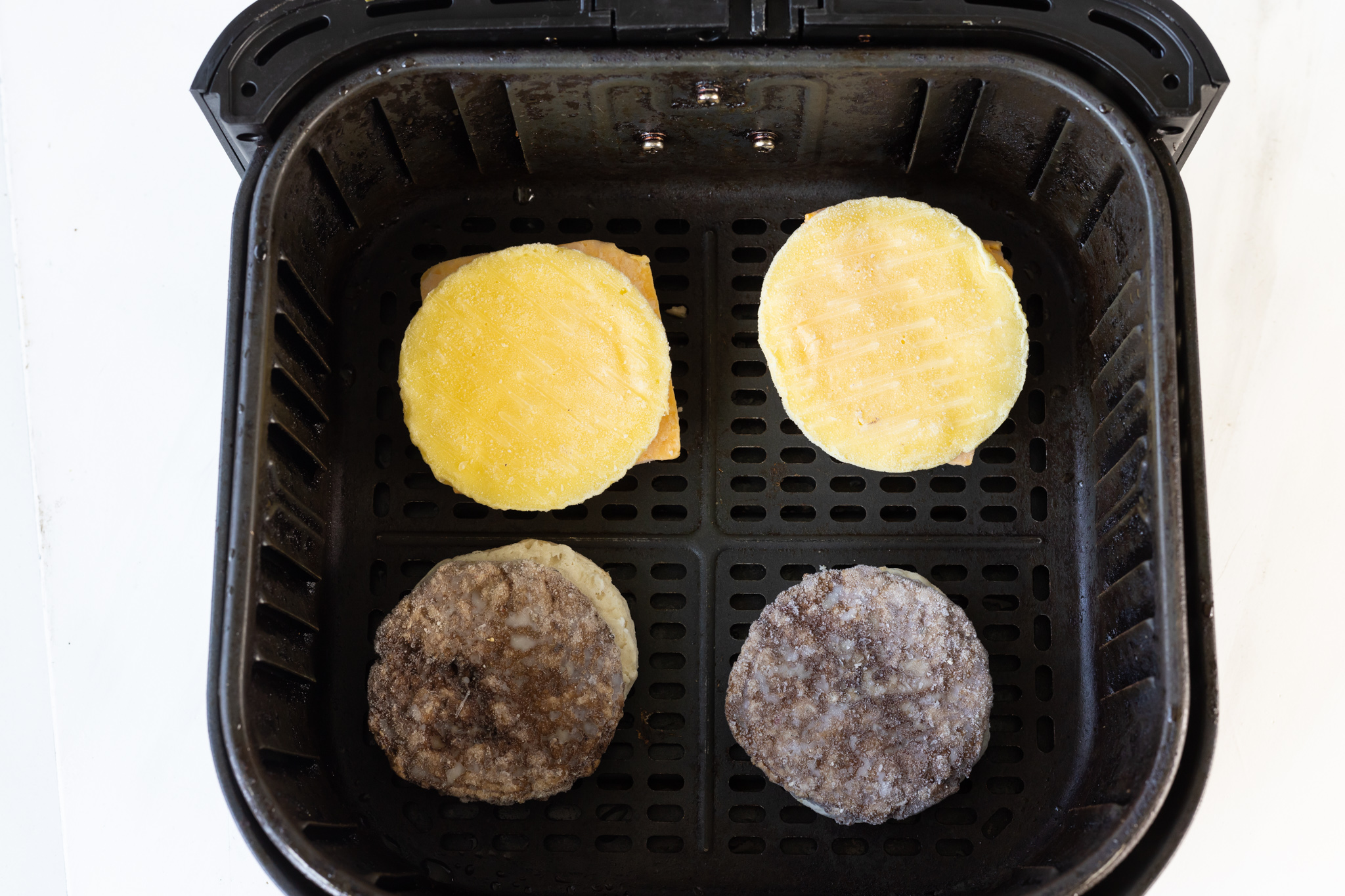 separated breakfast sandwiches in air fryer basket