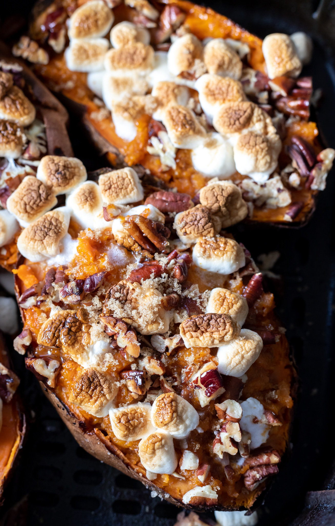 sweet potatoes topped with browned marshmallows in air fryer basket