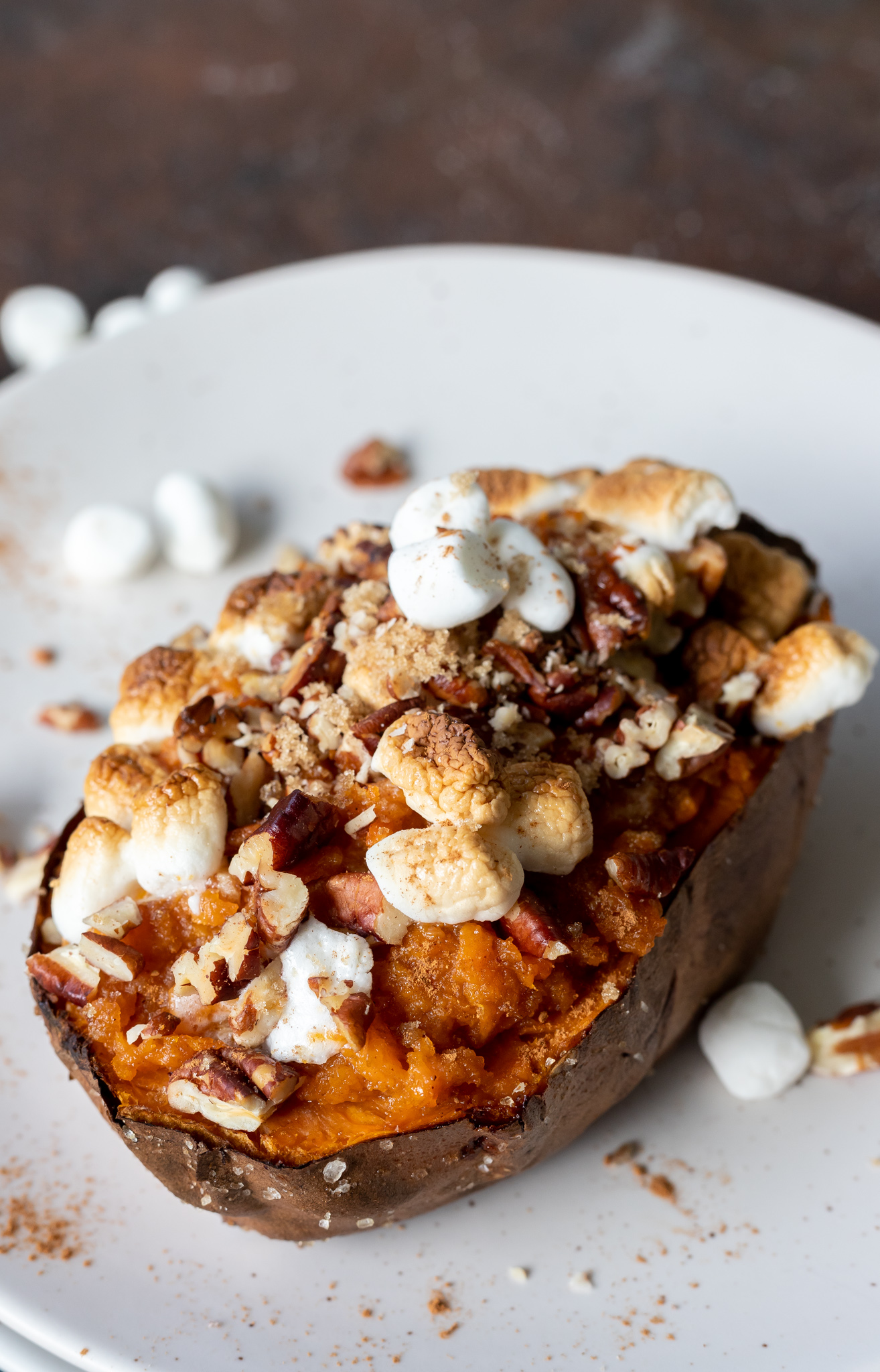 cooked sweet potato topped with marshmallows and pecans