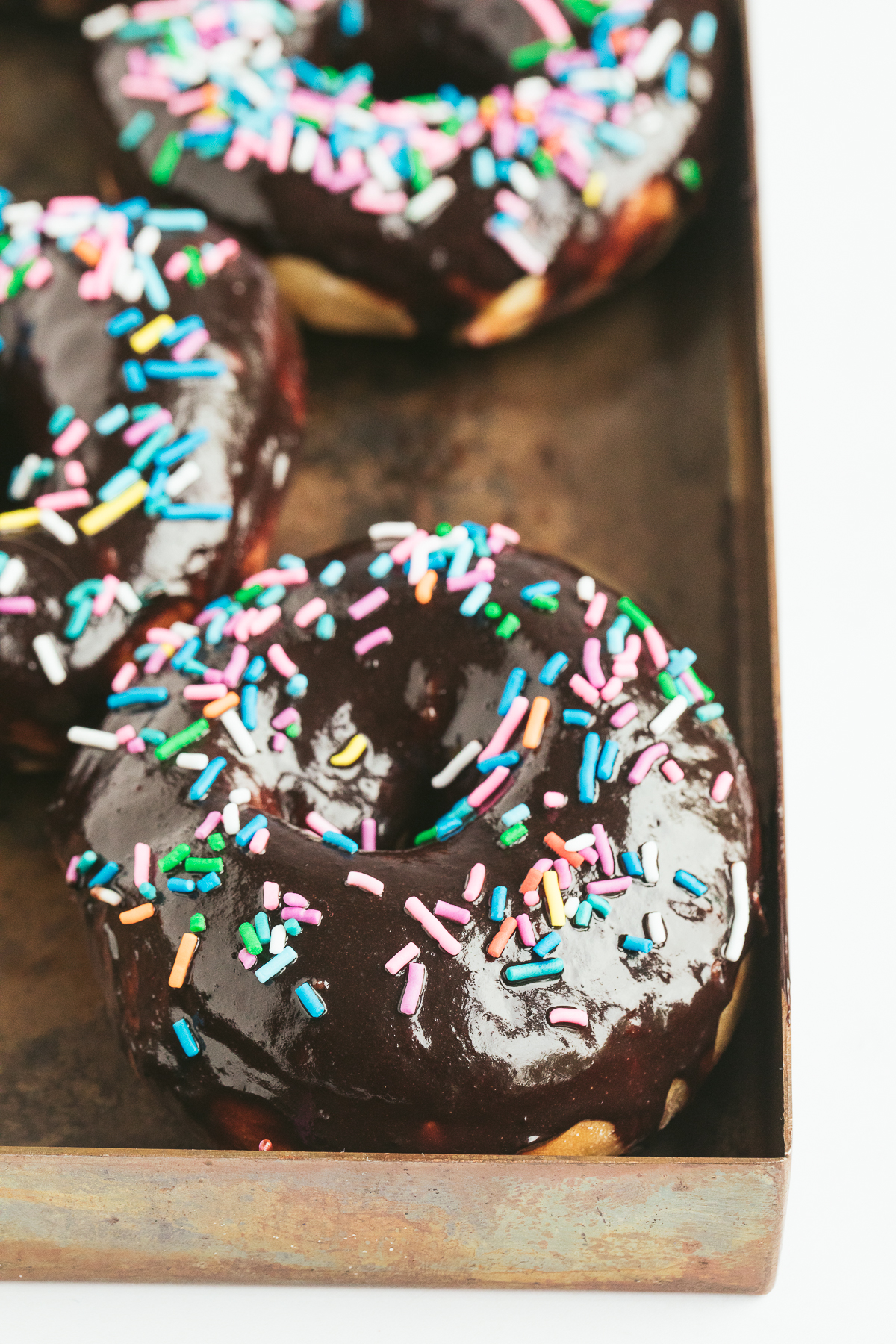 chocolate glazed donuts topped with colorful sprinkles